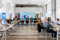 Uczestnicy II spotkania grupy roboczej ds. Regionalnych Planów Adaptacji do Zmian Klimatu siedzący na sali przy stole