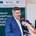 Przewodniczący Sejmiku Województwa Śląskiego udziela wywiadu mediom po konferencji, w tle baner o planie adaptacji do zmian klimatu.