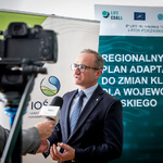 Wicemarszałek Województwa Śląskiego udziela wywiadu dziennikarzowi, obok kamera nagrywa rozmowę, w tle banery projektu LIFE COALA.