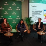 Panel dyskusyjny z pięcioma osobami na scenie, w tle ekran z agendą i plansza „Climate-Con”